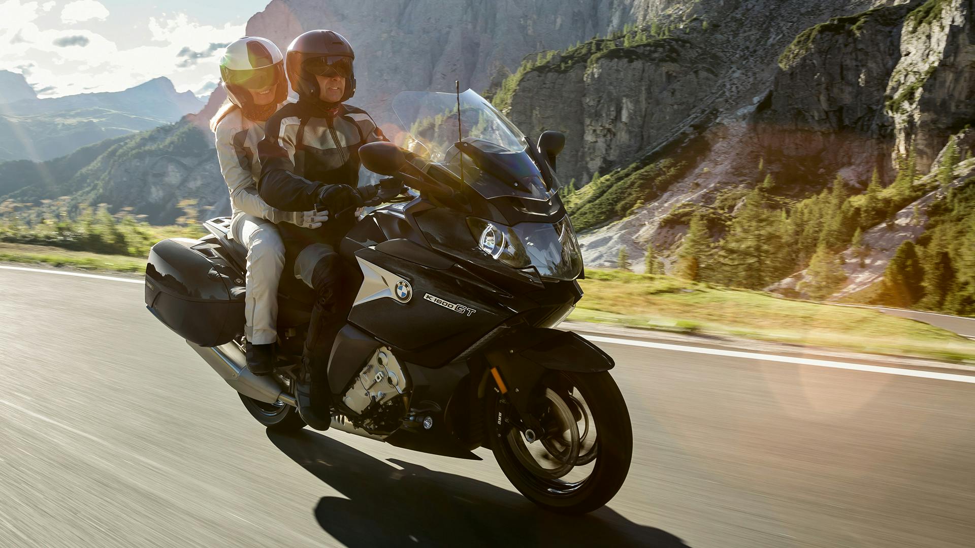 BMW K 1600 GT being ridden on the hill road with a passenger