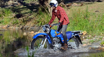 Yamaha AG200F in AG Blue colour crossing a creek