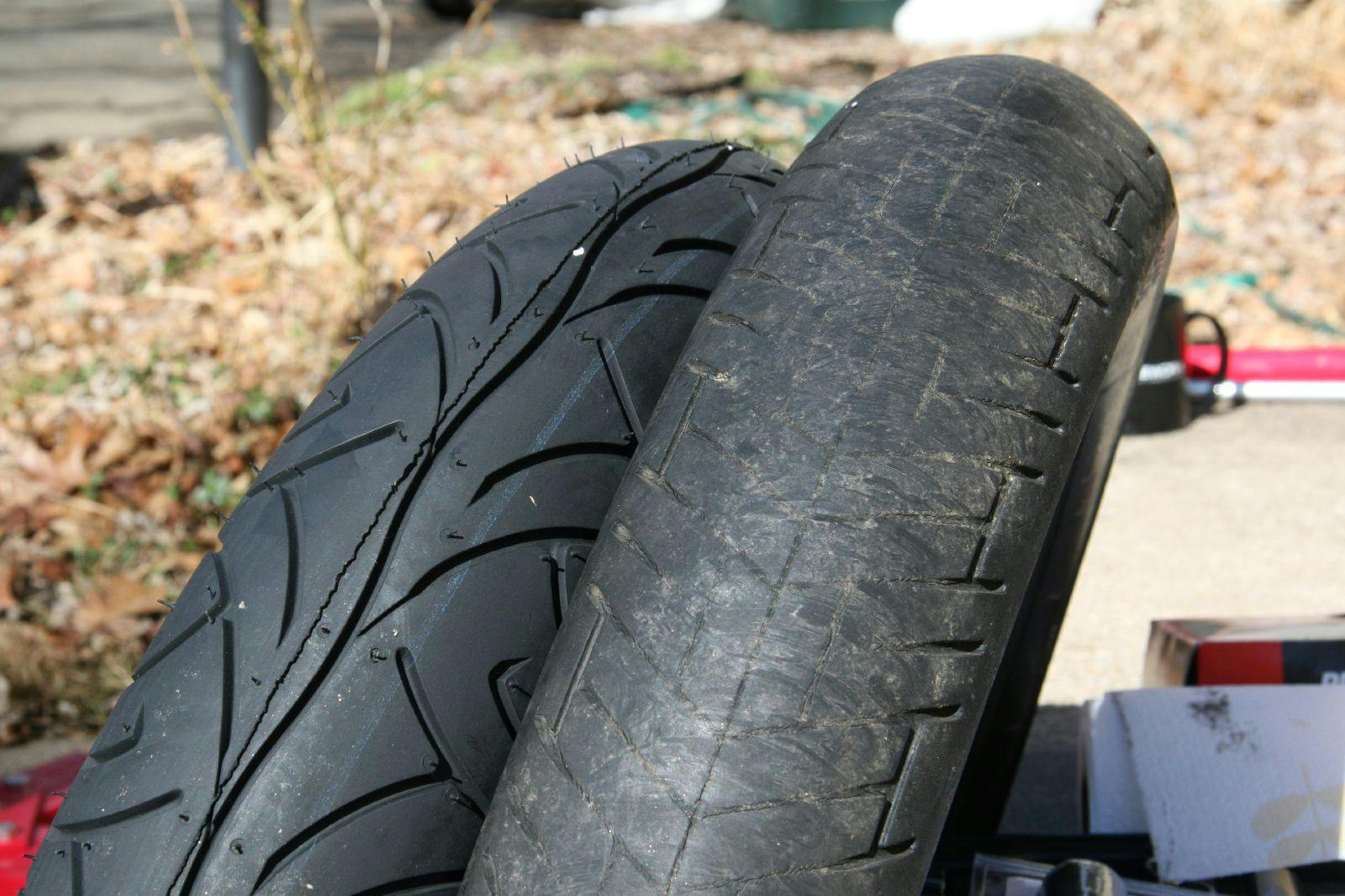 a brand new tyre next to a well worn tyre