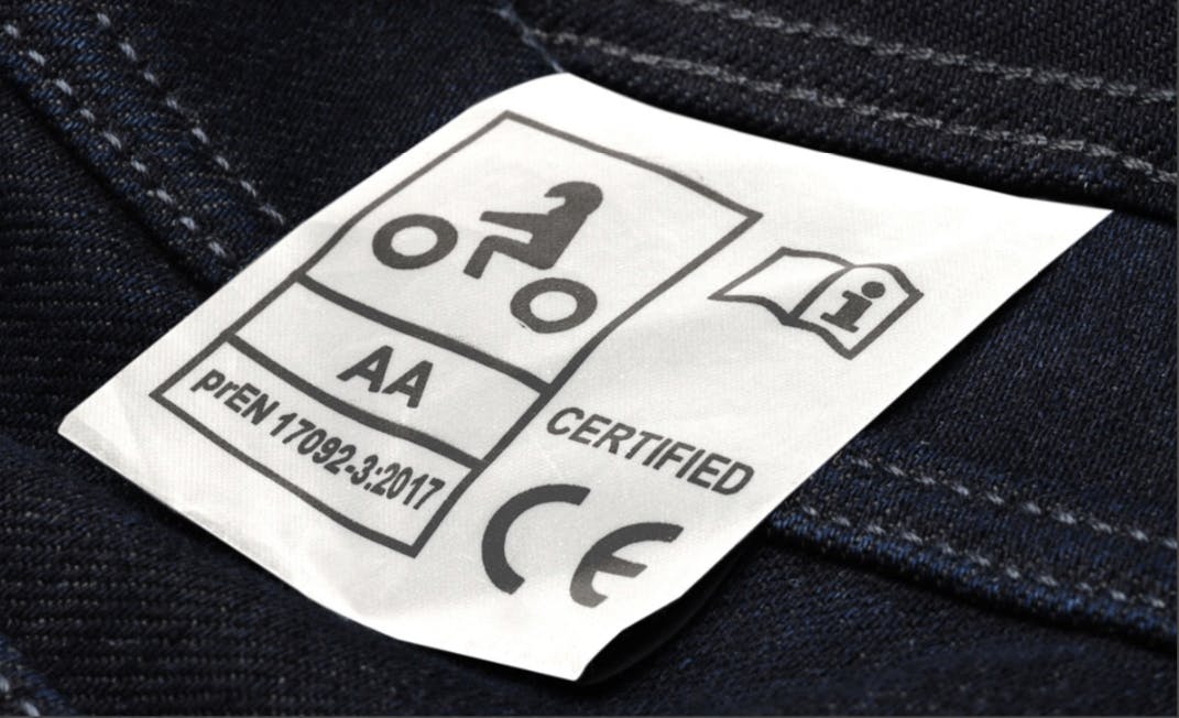 A close up of a CE certified tag on a pair of Macna jeans