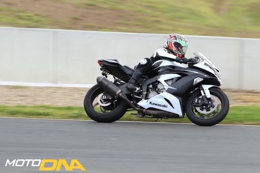 Girl on black and white motorcycle in full motorcycle gear 