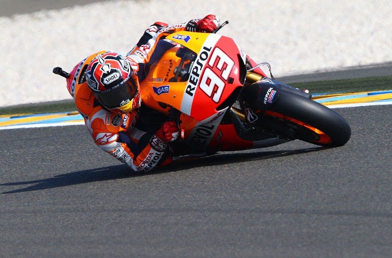 Marquez riding his motorcycle with his elbow on the track