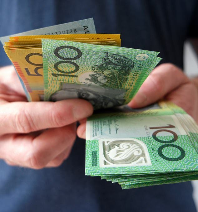 Hands with Australian $50 and $100 notes