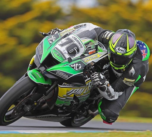 Ash DeBakker riding her motorcycle on the track