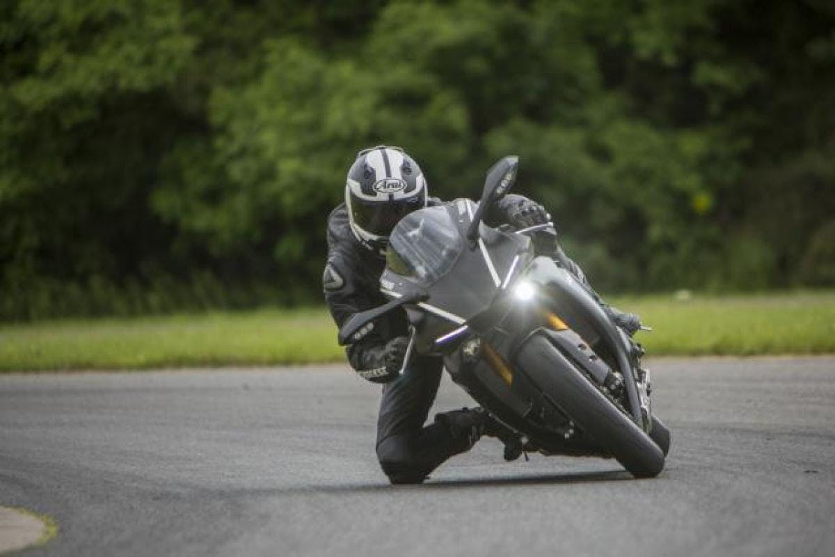 Rider dressed in black on a black motorcycle on the road