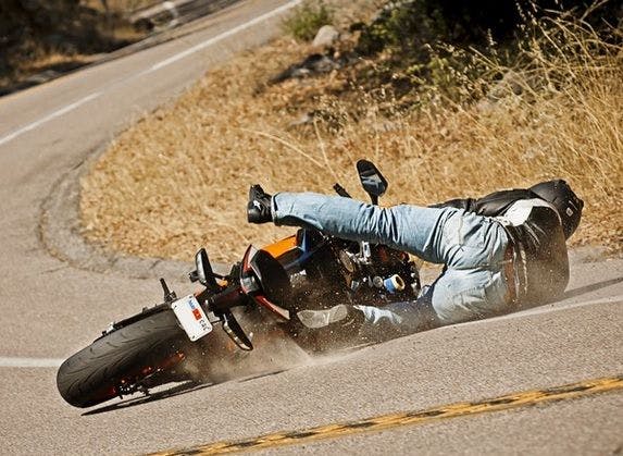 Man crashing on a motorcycle on the road