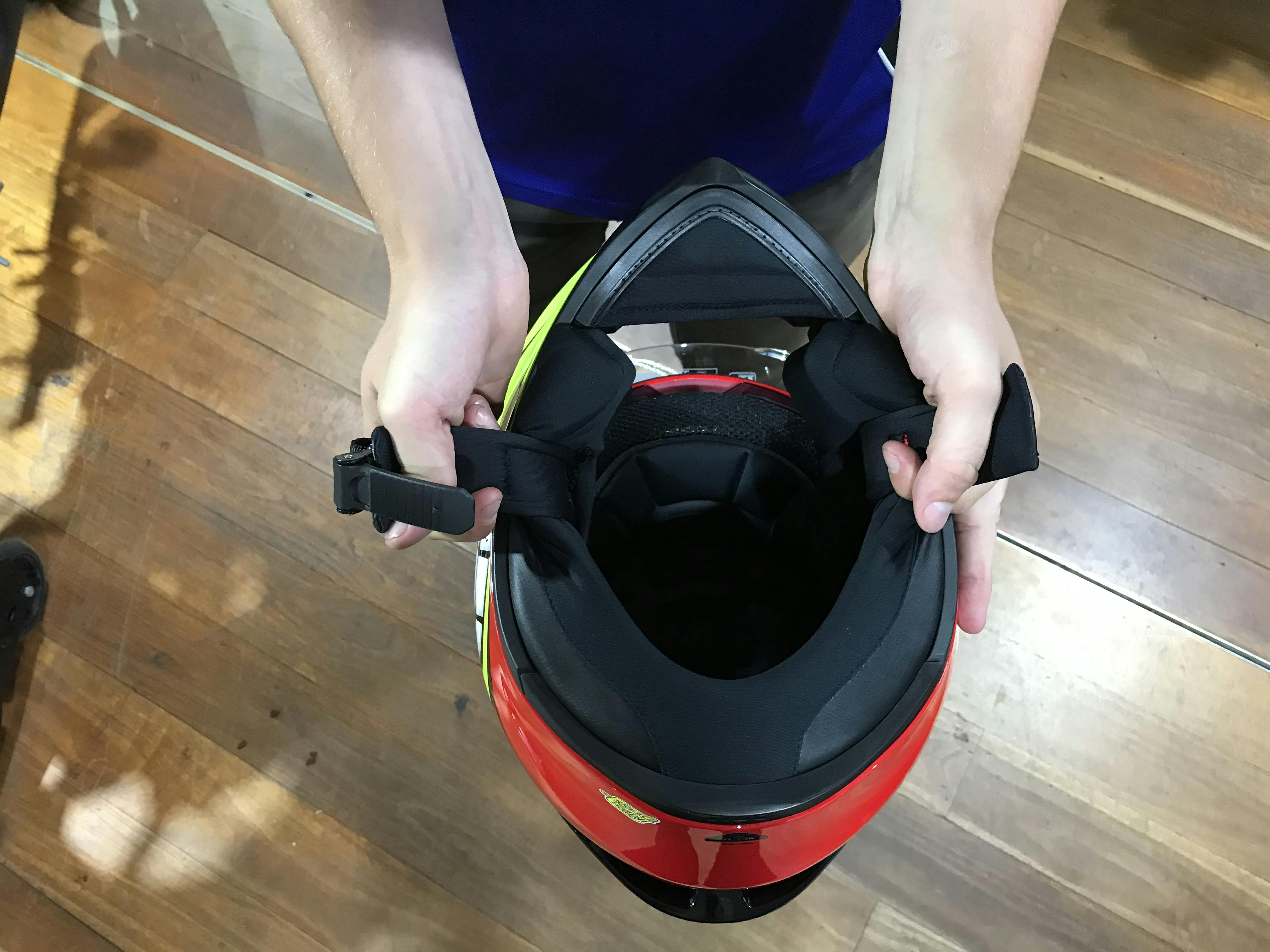 Guy opening the chin straps on a motorcycle helmet