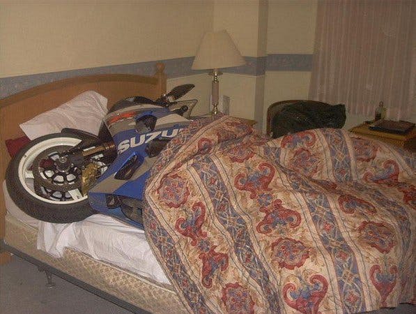 A motorcycle on a bed with a cover over it