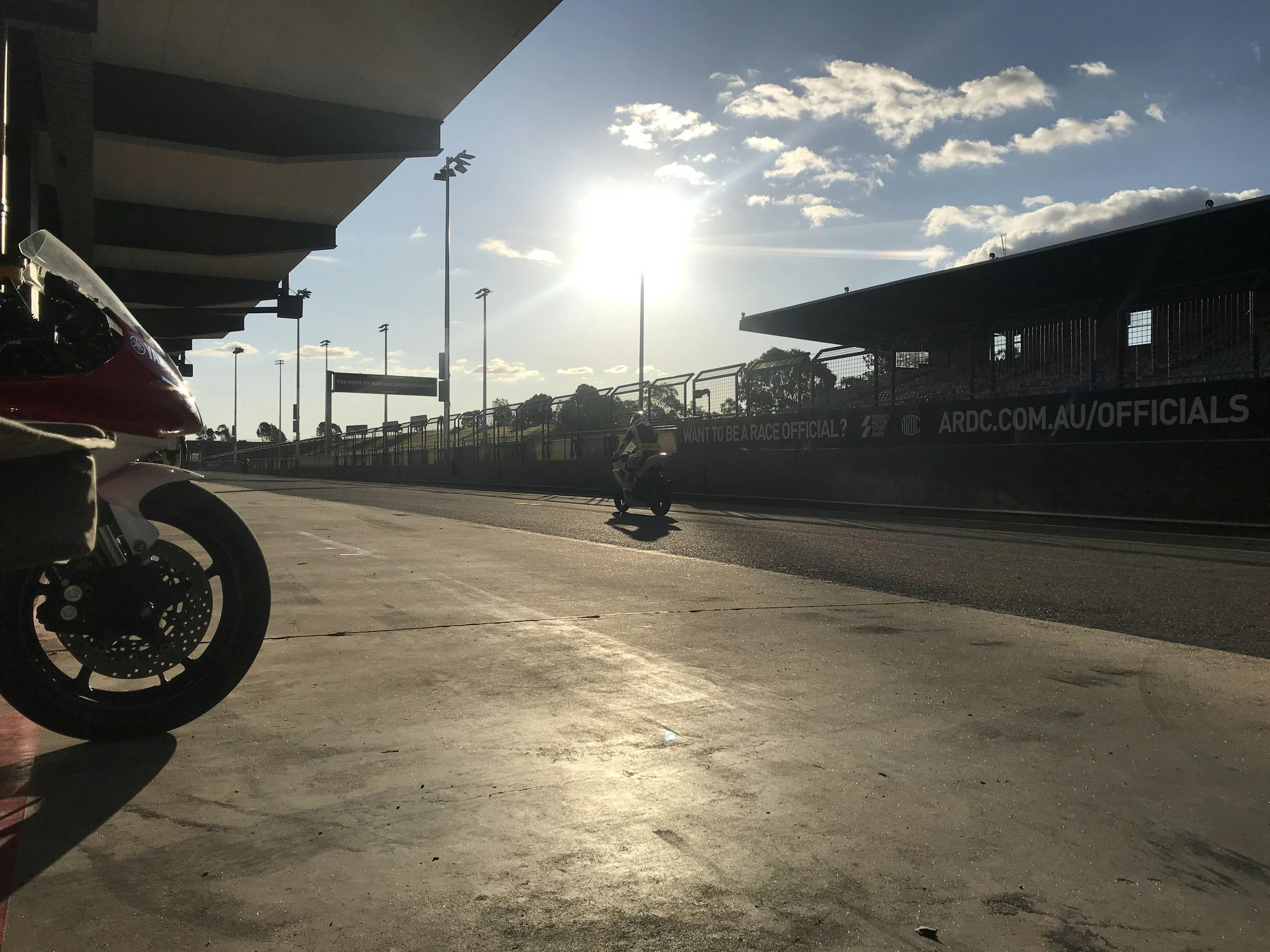 A race track with the sun dropping in the sky in the afternoon