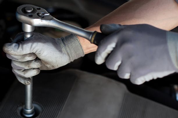Gloved hands using a torque wrench