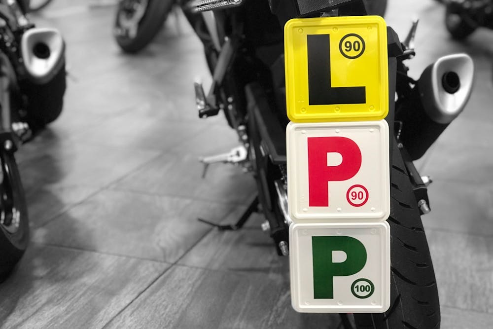 L, red P and green P plate all stuck together on the back of a motorcycle