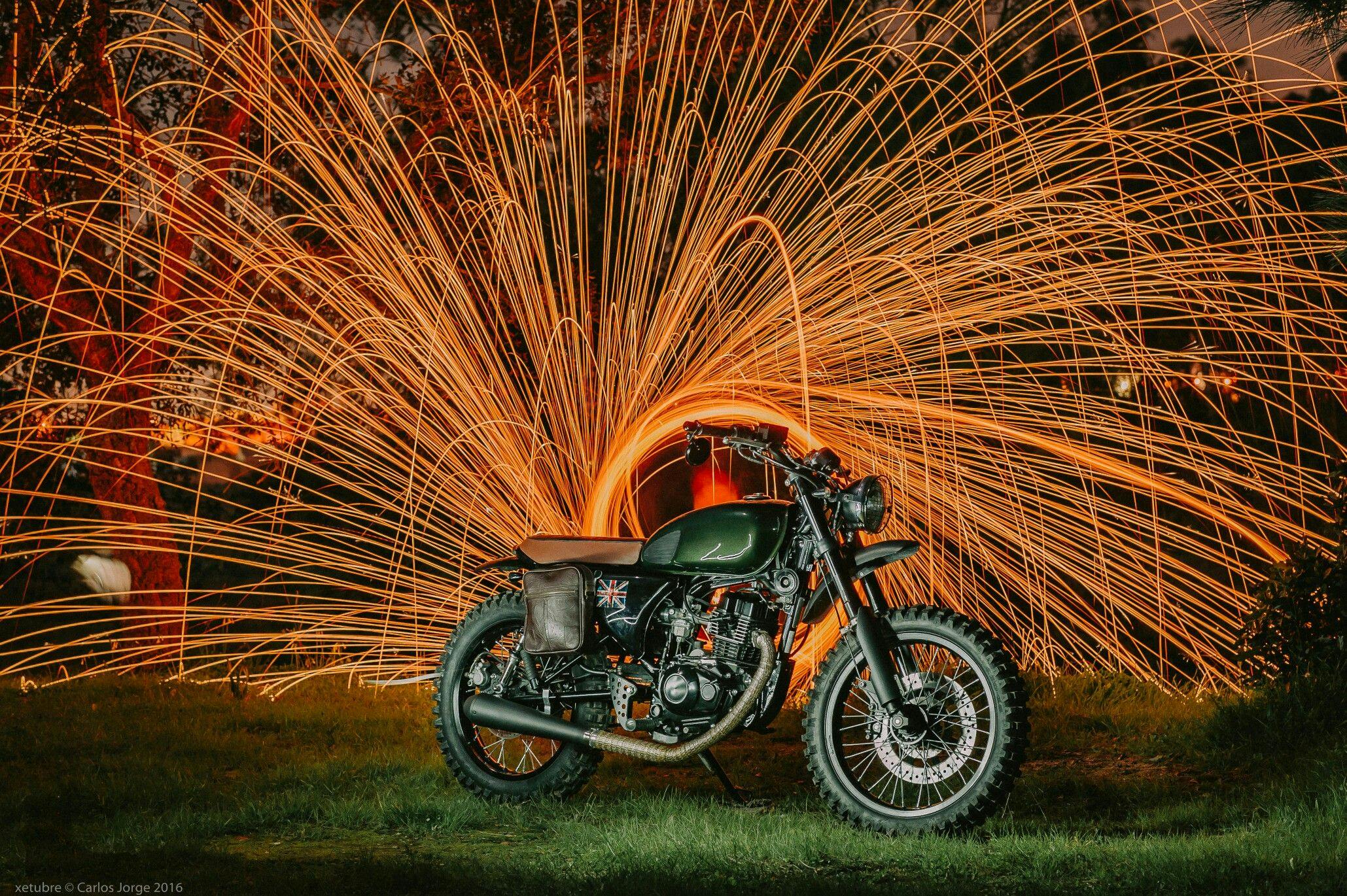 Old school motorcycle with orange fireworks in the background