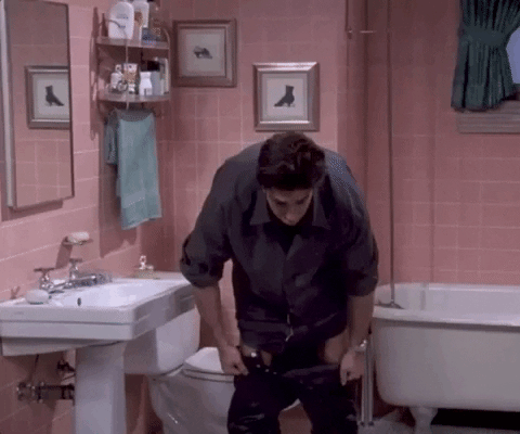 Ross from Friends pulling on leather pants GIF