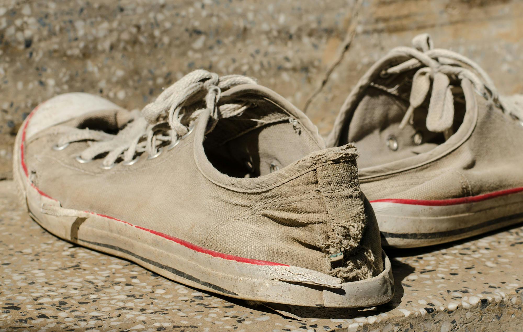 A pair of old sneakers with a hole in them