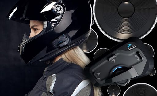 Cardo intercom system on a gloss black full face helmet on a blonde female