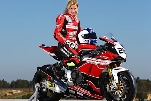 Jenny Tinmouth on a red motorcycle in red leathers
