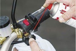 a can of cable lube sprayed on a motorcycle