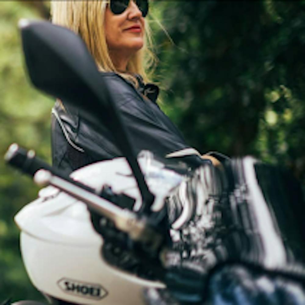 Blonde woman with a white helmet and a Triumph motorcycle
