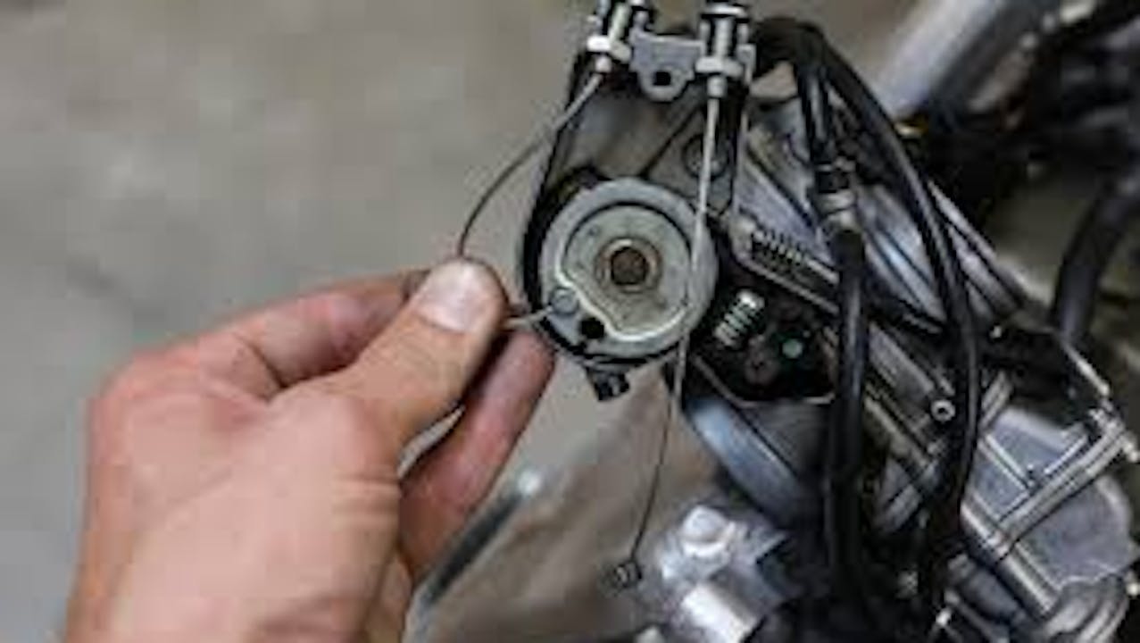Hand adjusting a cable on a motorcycle