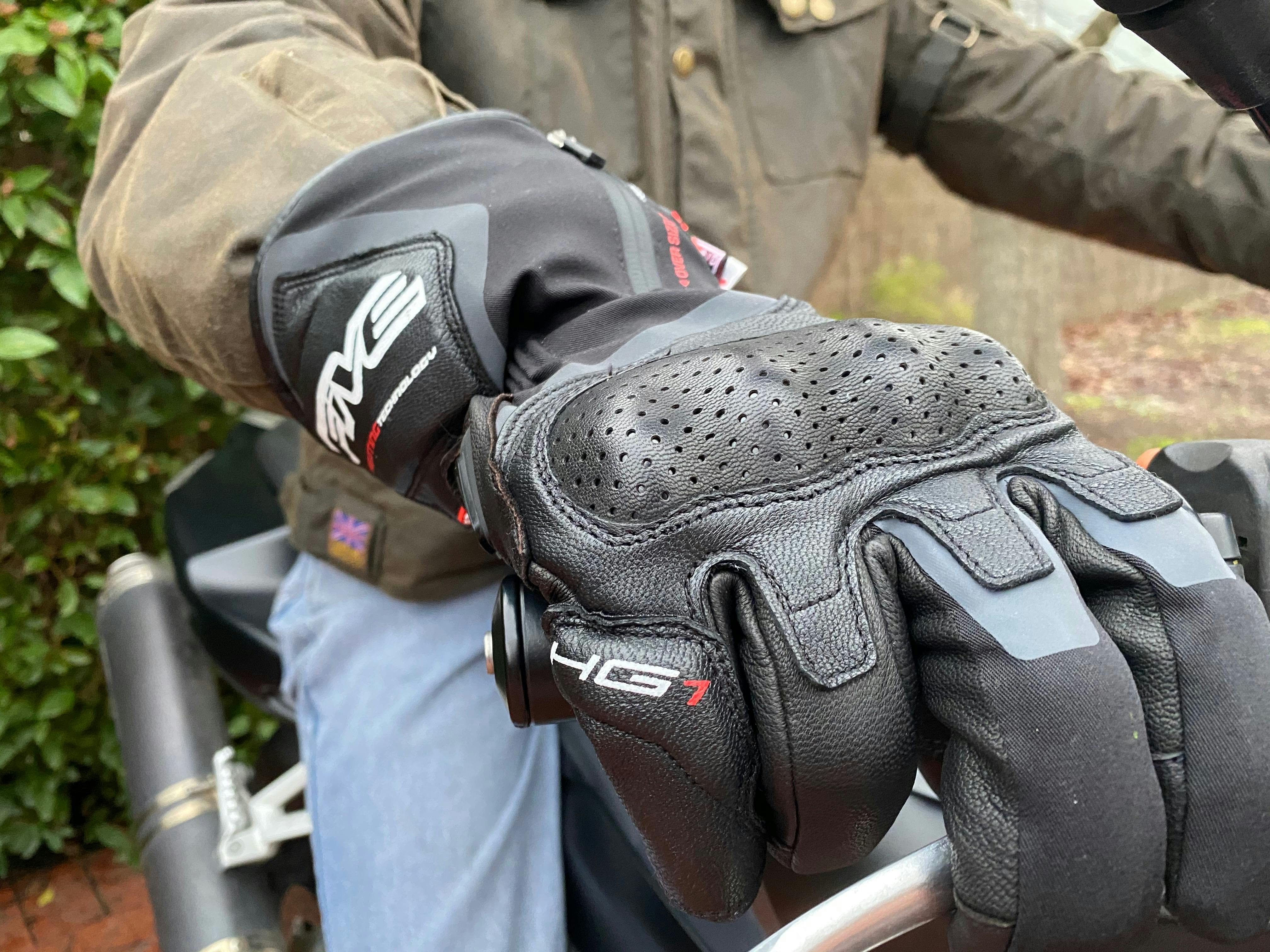 The Five HG-1 heated glove on a mans hand on a motorcycle handlebar