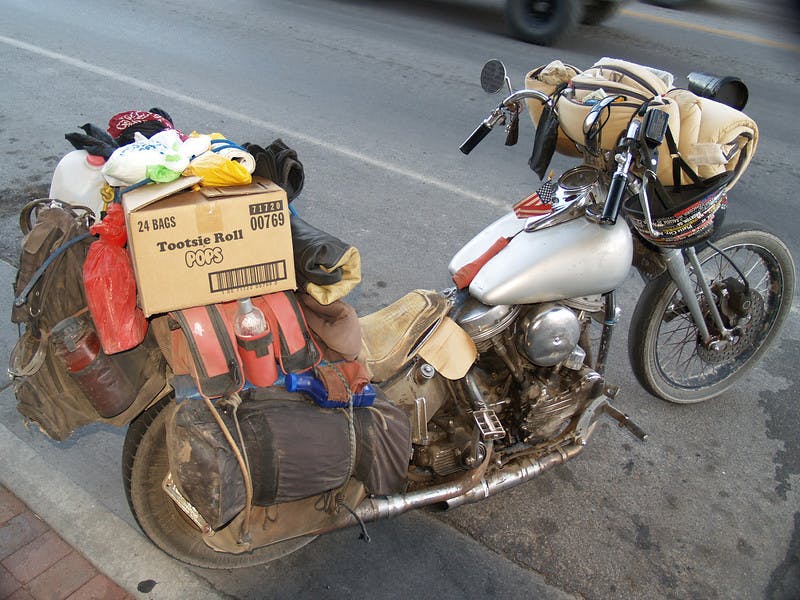 a silver motorcycle overfilled with luggage