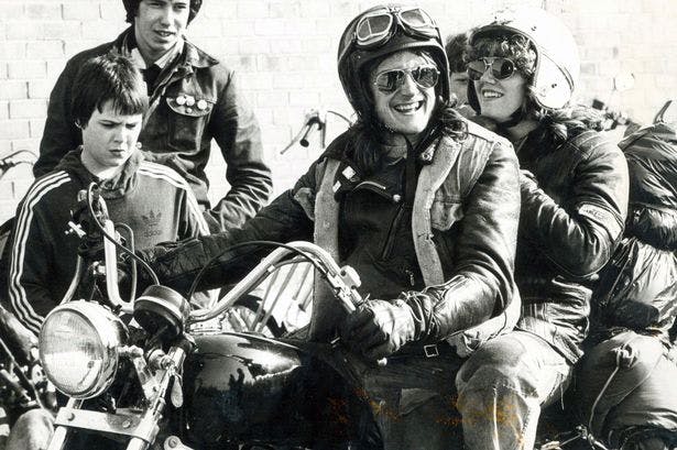 Old photograph in black and white of a man and woman on a motorcycle