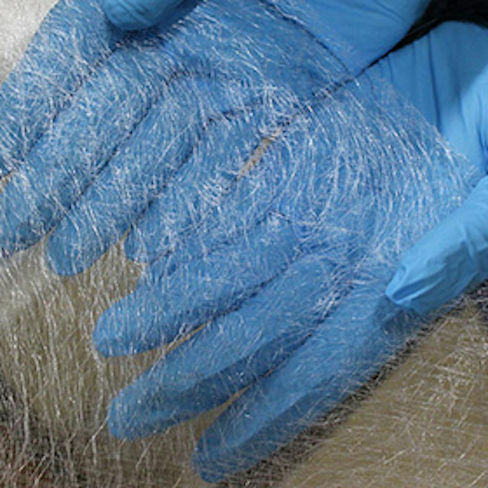 Raw fiberglass on blue gloved hands