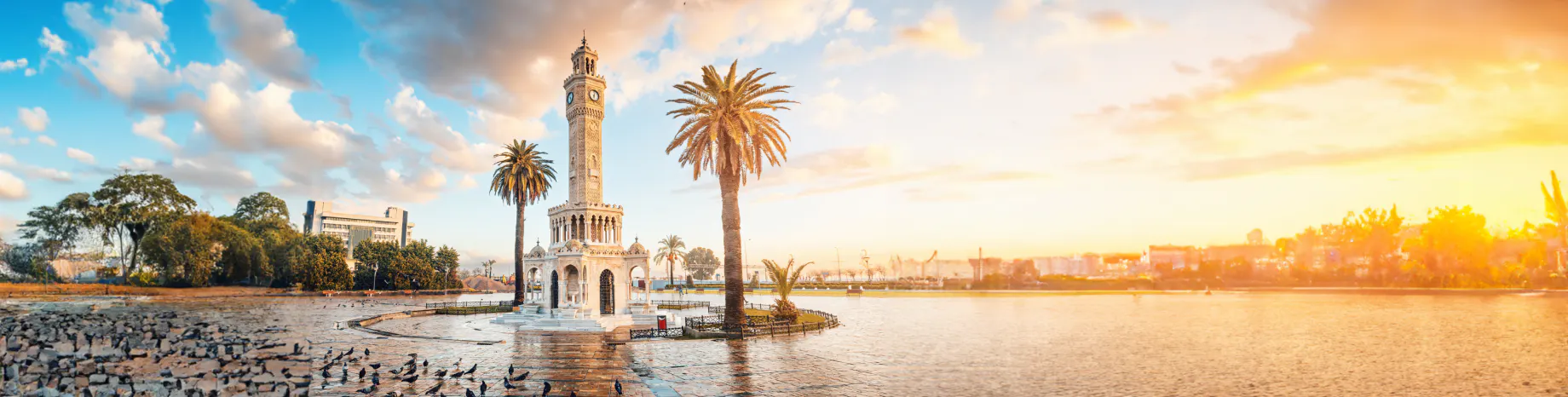Konak Meydanı'nda palmiyeler arasında İzmir Saat Kulesi ve gün batımı
