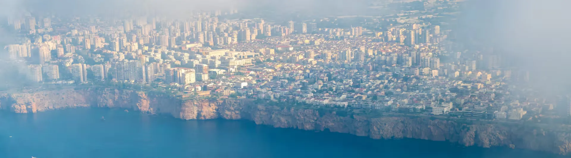 Antalya falezleri, masmavi Akdeniz ve kıyıdaki şehir silueti, Bodrum - Antalya otobüs bileti kapak görseli