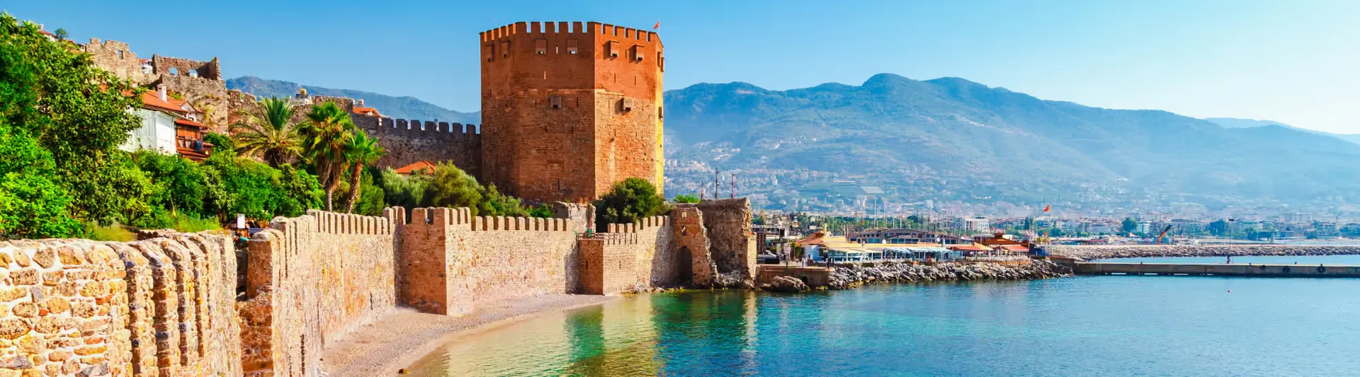 Alanya'daki tarihi Kızıl Kule ve dağ manzarası, Eskişehir - Antalya otobüs bileti kapak görseli