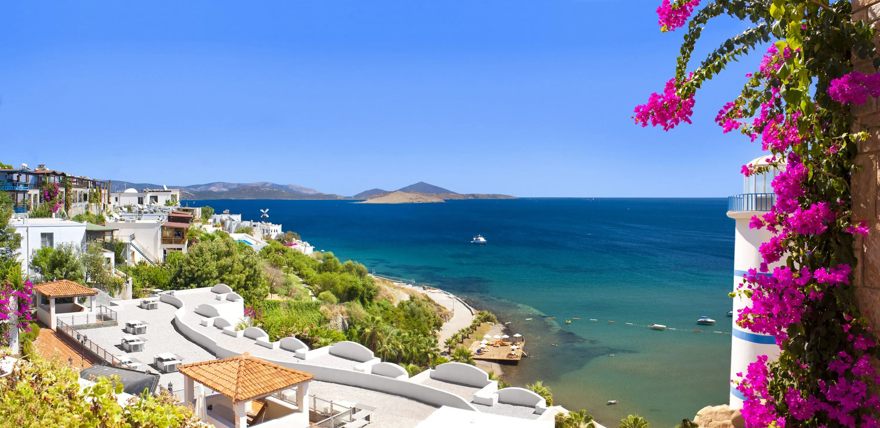 Begonviller arasından Bodrum koyu ve yamaçtaki beyaz evler