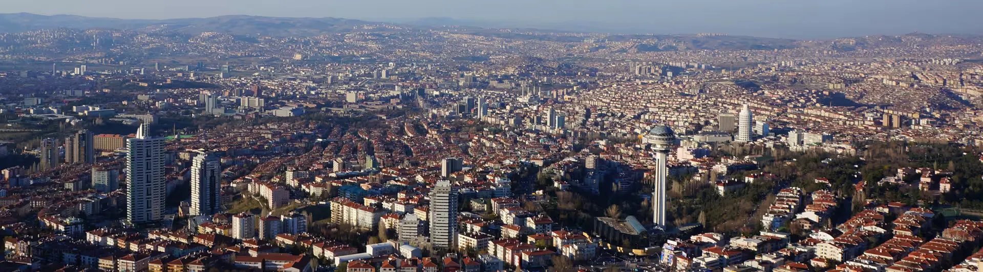 Kuşbakışı Ankara şehir silüeti ve modern Başkent manzarası eşliğinde en uygun Ankara otobüs bileti seçenekleri seyahat rehberi kapak görseli.