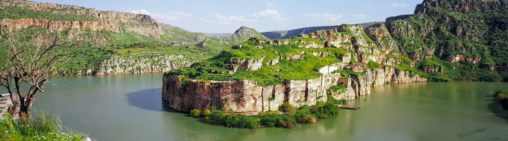 Karşıdan Rumkale tarihi taş duvarları ve Fırat Nehri'nin masmavi suları manzarası eşliğinde en uygun Gaziantep seyahat rehberi kapak görseli.