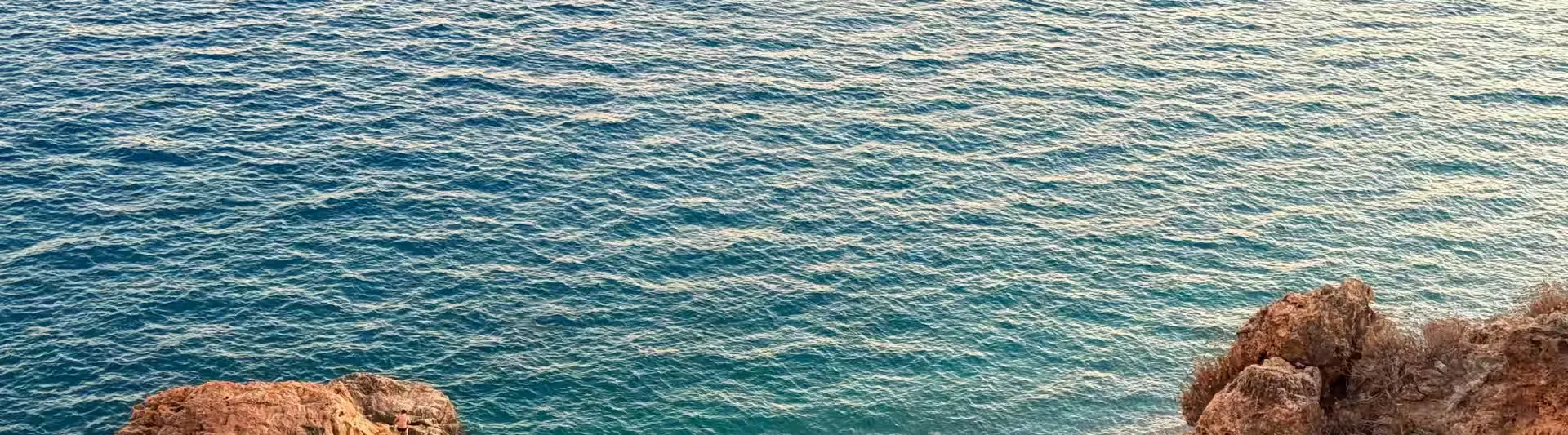 Antalya Otobüs Bileti- Masmavi Akdeniz sularının vahşi doğal kayalıklarla buluştuğu panoramik sahil manzarası; biletiniz.com üzerinden en ucuz uçak biletleri ve otobüs biletleri için dinlendirici kapak görseli.