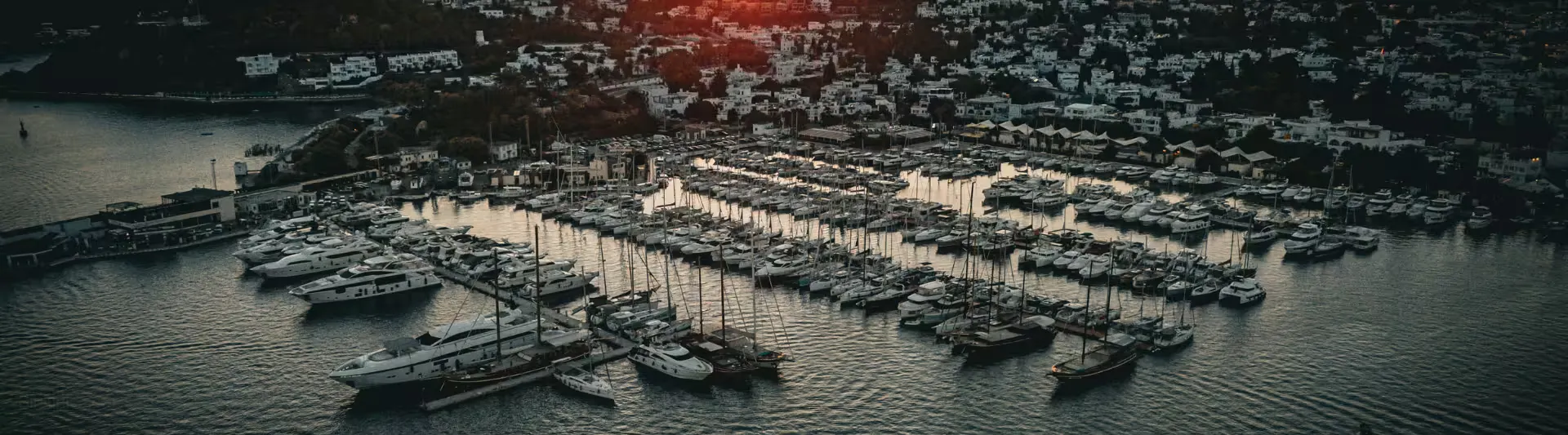 Bodrum marinasının panoramik görünümü ve gün batımında demirli tekneler, Antalya Bodrum otobüs bileti kapak görseli