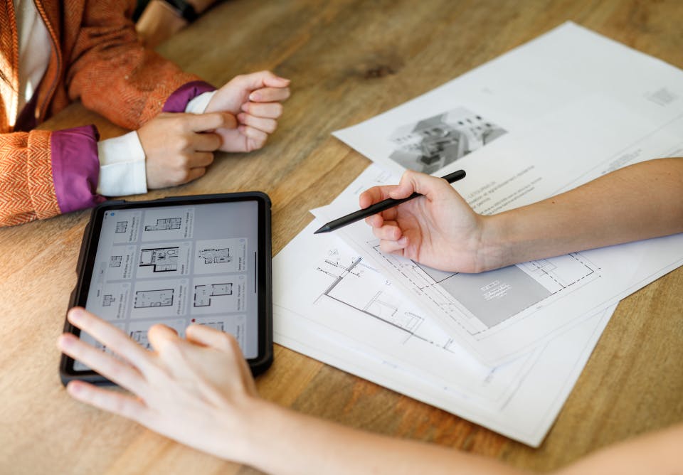 Architecte en train de regarder des plans avec des propriétaires