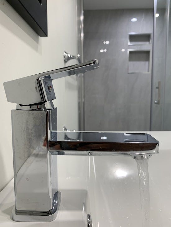 Gros plan du robinet de la salle de bain du sous-sol rénové Gros plan du robinet de la salle de bain du sous-sol rénové
