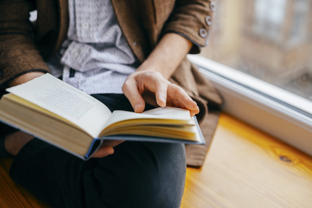 Personne tenant un livre afin de faire de la recherche