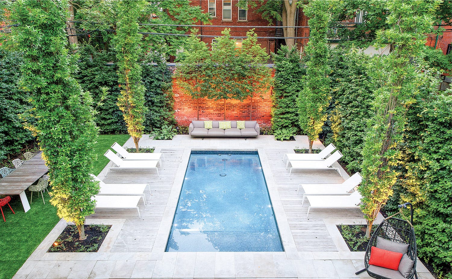 Swimming pool design tips to revive your backyard Backyard swimming pool surrounded by cedars
