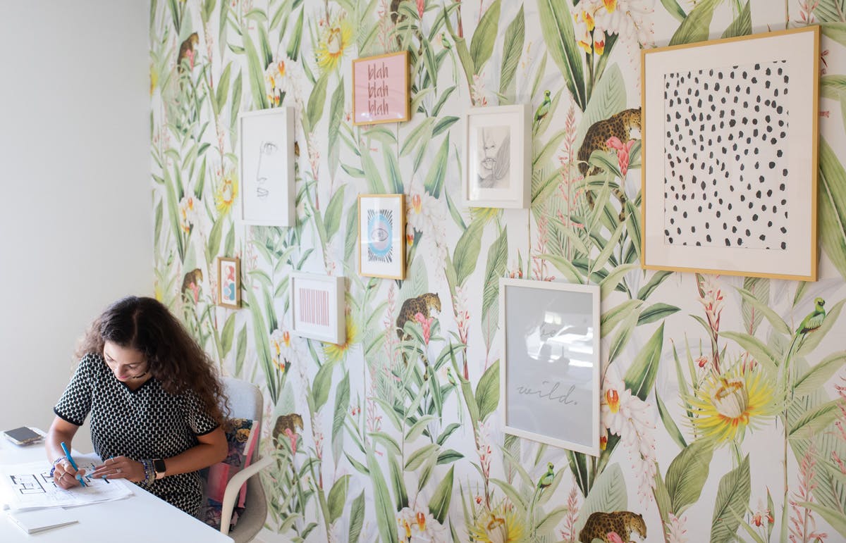 Jude Kamal sitting at a desk Jude Kamal, interior designer and founder of Sansa Interiors sitting at a desk