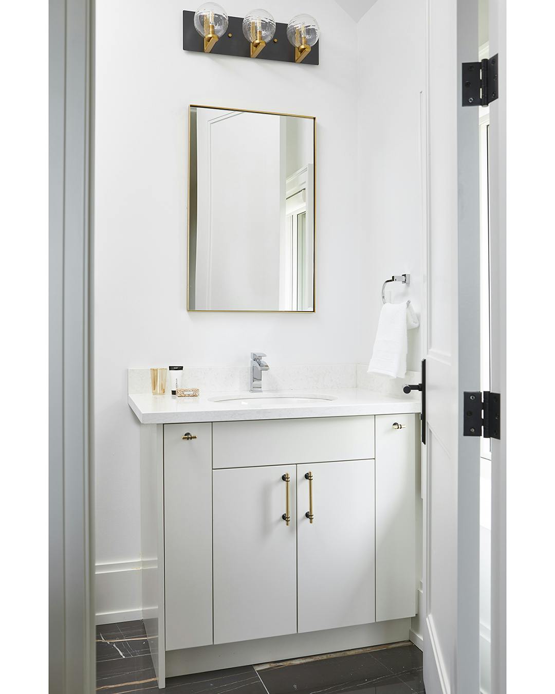 Modern bathroom with gold fixtures and dark marble flooring