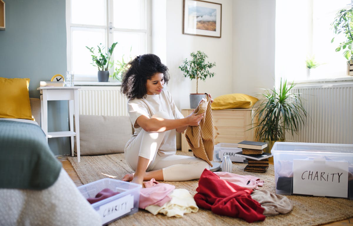 Thin out your belongings prior to renovating Woman sorting clothes to give away