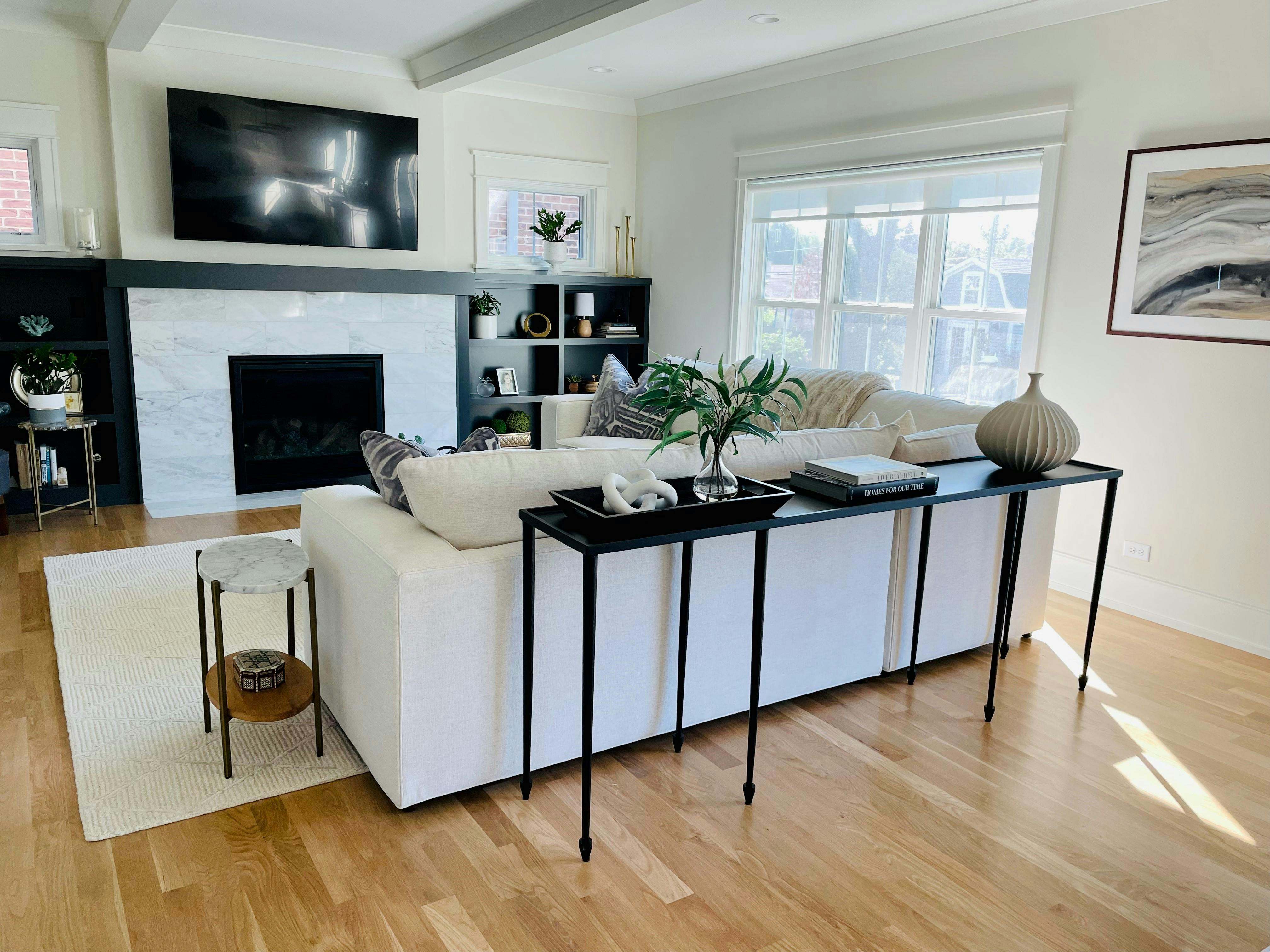 Salon avec une cheminée en marbre blanc et un manteau noir
