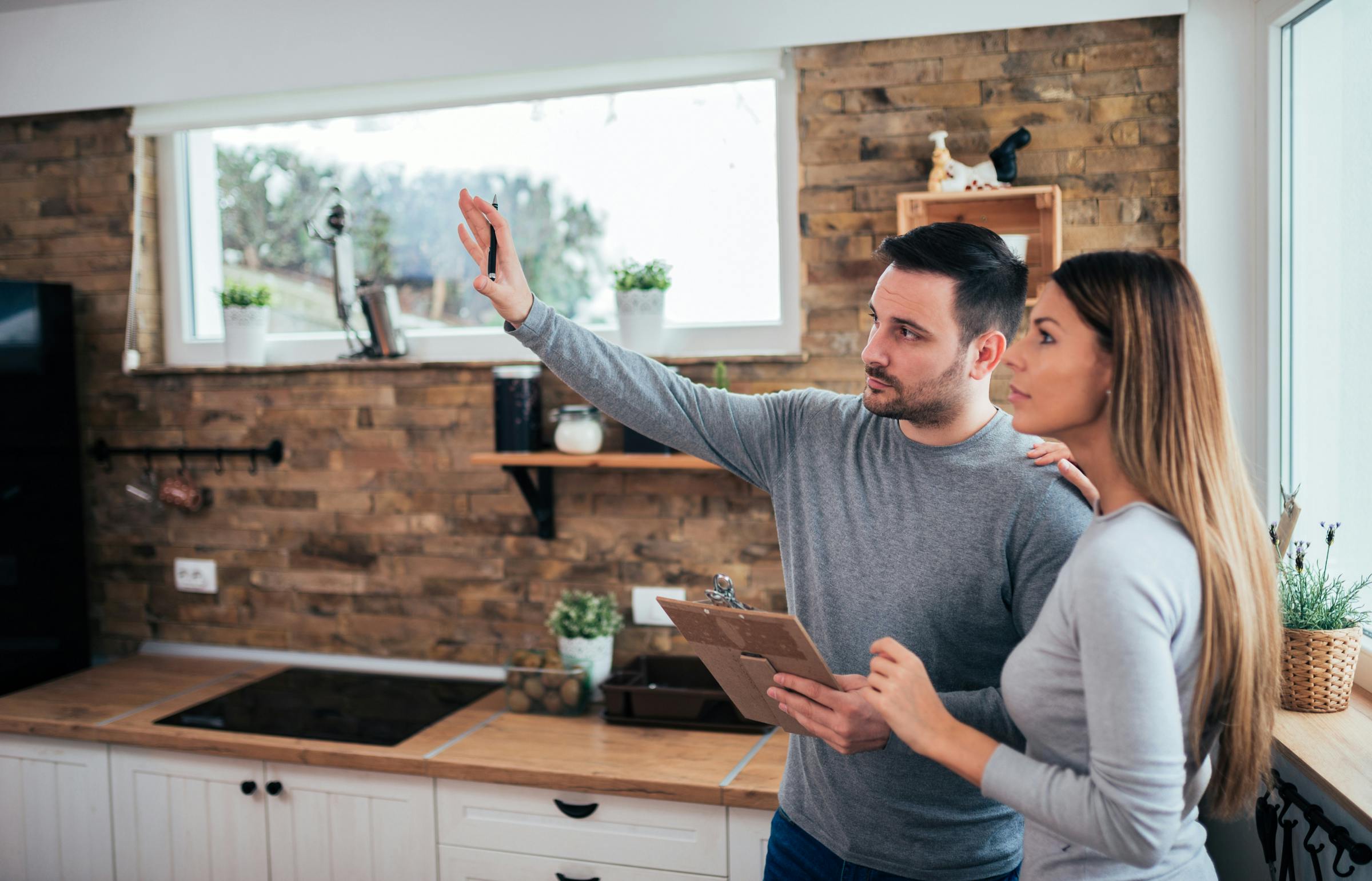 Couple dans leur cuisine qui priorise le travail allant dans leur rénovation Couple dans leur cuisine qui priorise le travail allant dans leur rénovation