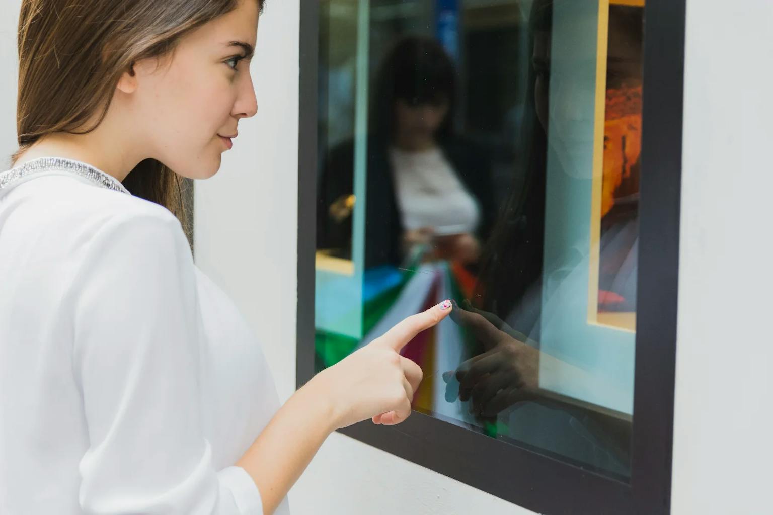 Femme qui utilise une borne de commande dans un magasin digitalisé.