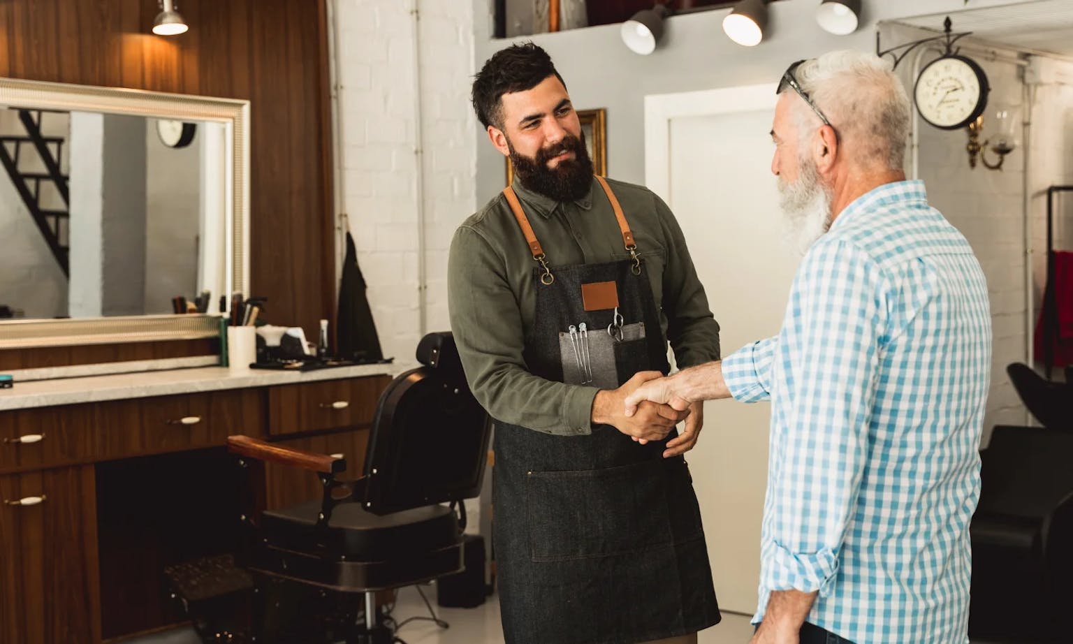 Coiffeur qui donne une carte de fidélité coiffure à son client. 