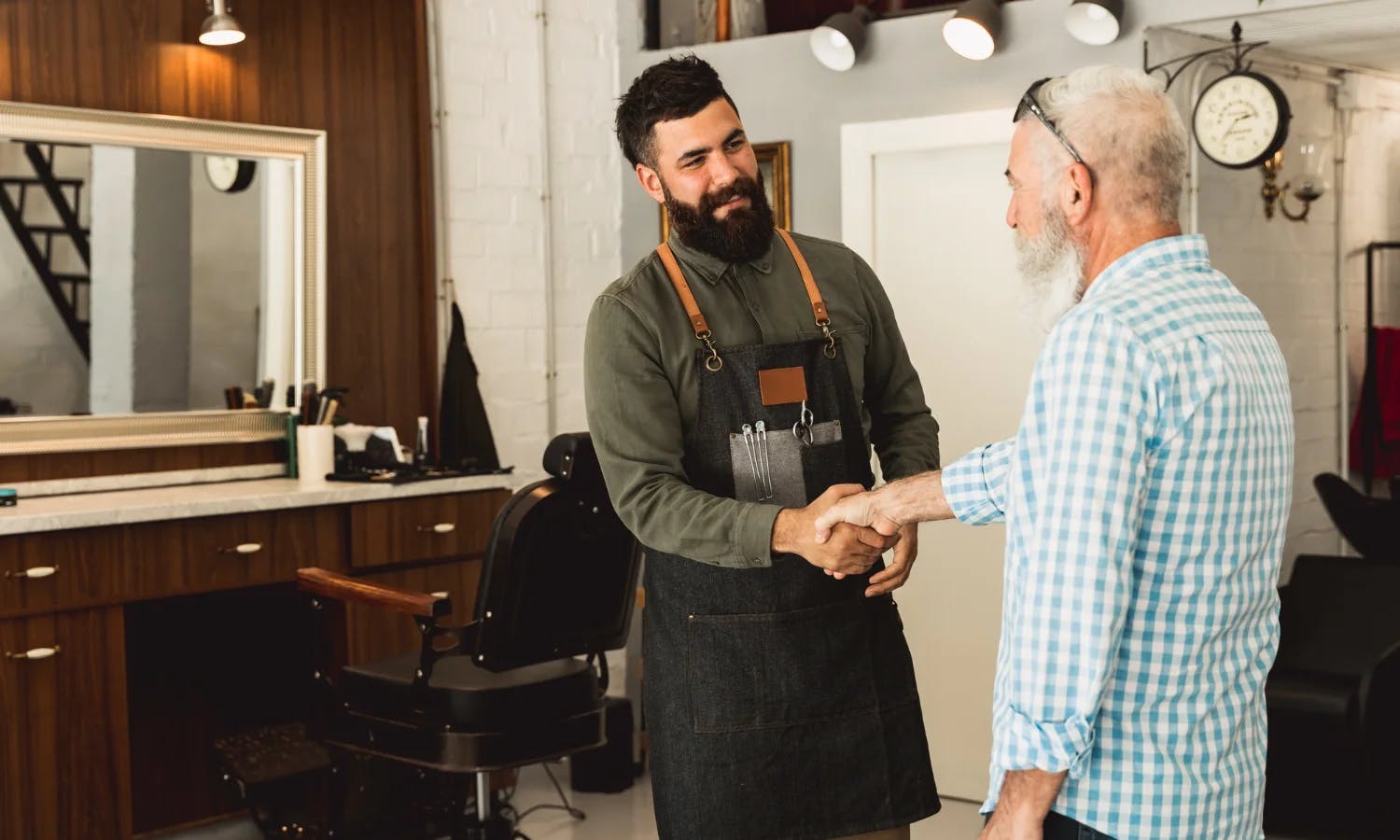 Coiffeur qui donne une carte de fidélité coiffure à son client.
