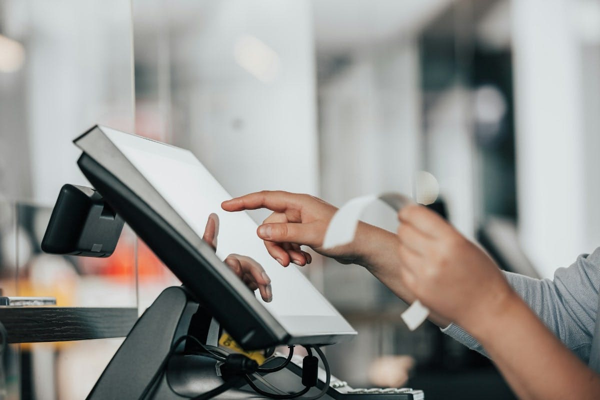 Commerçant qui tient un ticket de caisse 