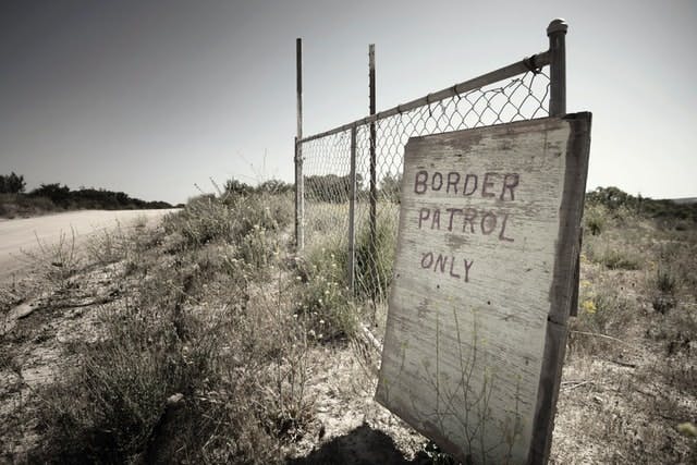 Sign on wire fence saying Border Patrol Only - Image by Greg Bulla on Unsplash