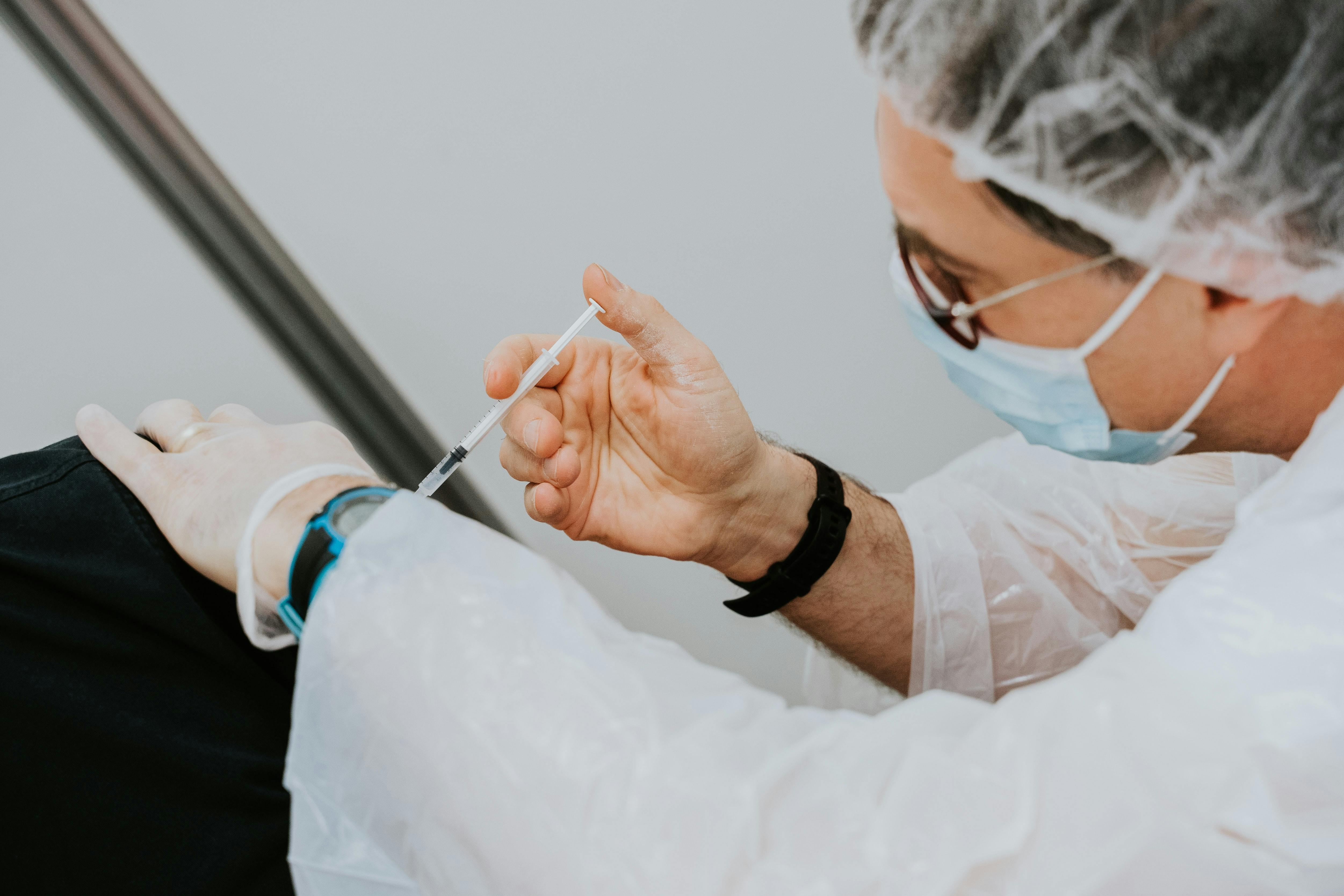 medical professional giving someone a vaccine - Photo by Mat Napo on Unsplash